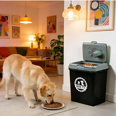 A black and gray pet waste bin with an open lid, shown next to a yellow Labrador retriever eating dry dog food in a warmly lit living room.