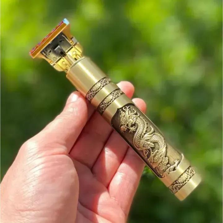 Decorative gold and bronze hair trimmer held in a hand with a blurred green background