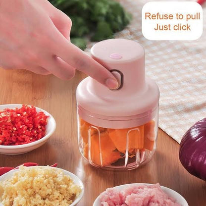 Handheld food chopper with chopped vegetables on a wooden table